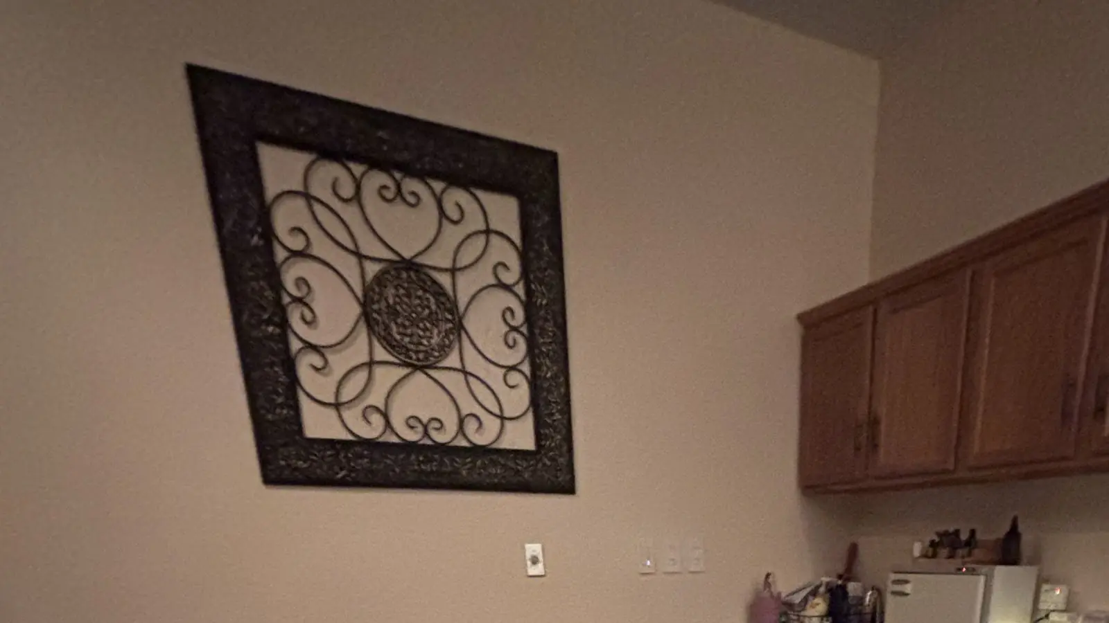 A scrollwork panel on the warm wall of a Fluid Energies treatment room