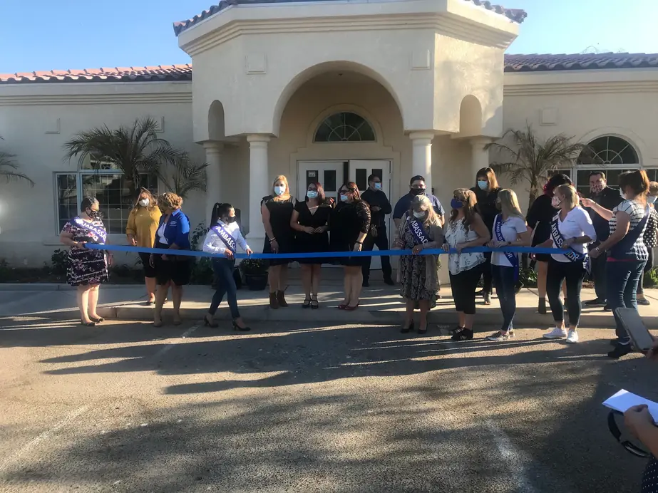 Staff and guests in masks outside the building at a ribbon-cutting